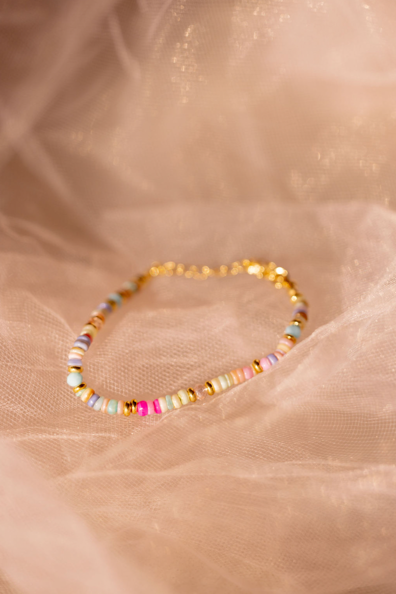 Multicolored beaded bracelet on a soft beige fabric background