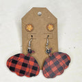 Red and black buffalo plaid pumpkin dangle earrings and sparkly golden round stud earrings on a display card