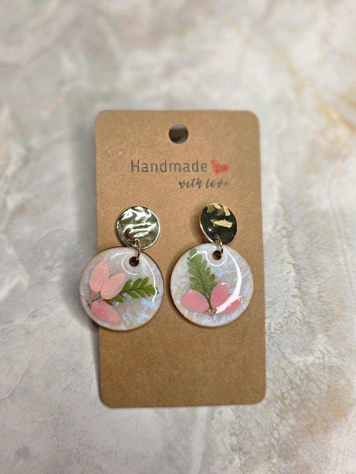 Handmade hexagon stud earrings with red and black floral print in clear resin on kraft earring card