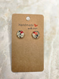 Handmade pearlescent resin drop earrings with pink butterfly and green fern design on gold coin stud top on kraft earring card